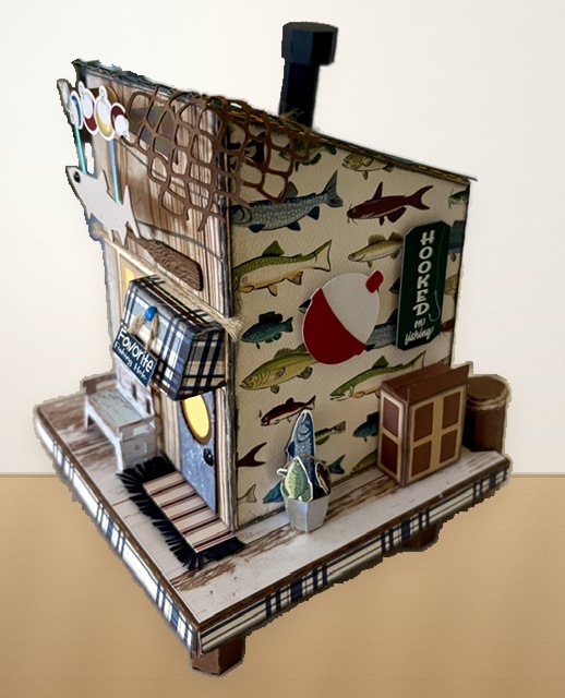 Side view of the Bait House showing fish-patterned siding, bobber decoration, hooked sign, and miniature dock details